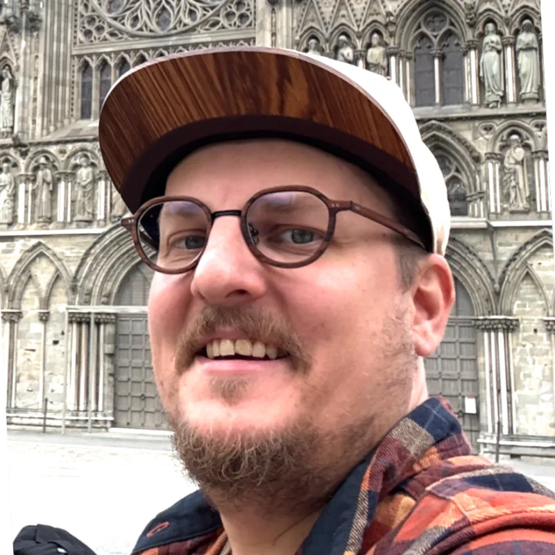 Daniel Pastva v kšiltovce a brýlích před katedrálou